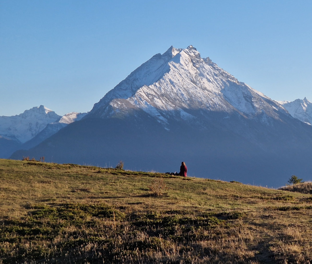 Frau sitz alleine vor einem Berg